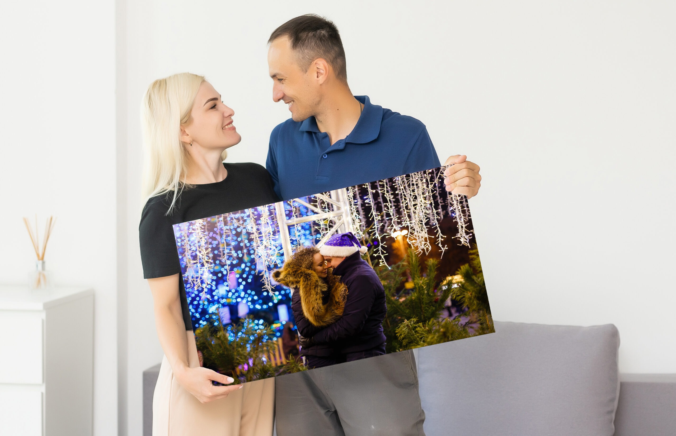 a man and a woman holding a photo canvas